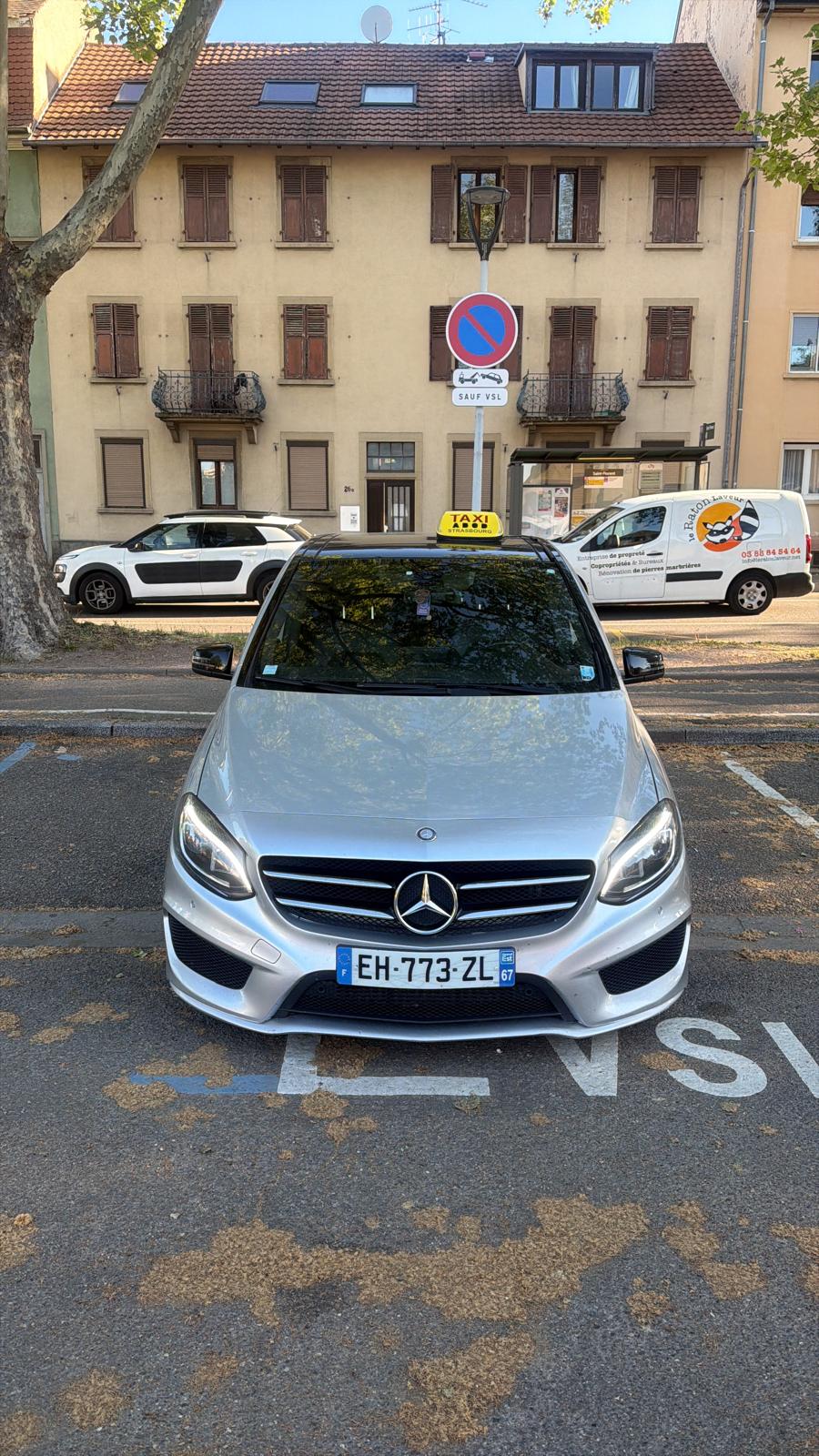 Taxi Sam, berline de taxi stationnée sur une place réservée VSL
